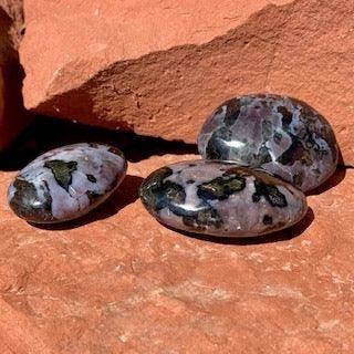 Mystic Merlinite palmstone with swirling deep color pattern