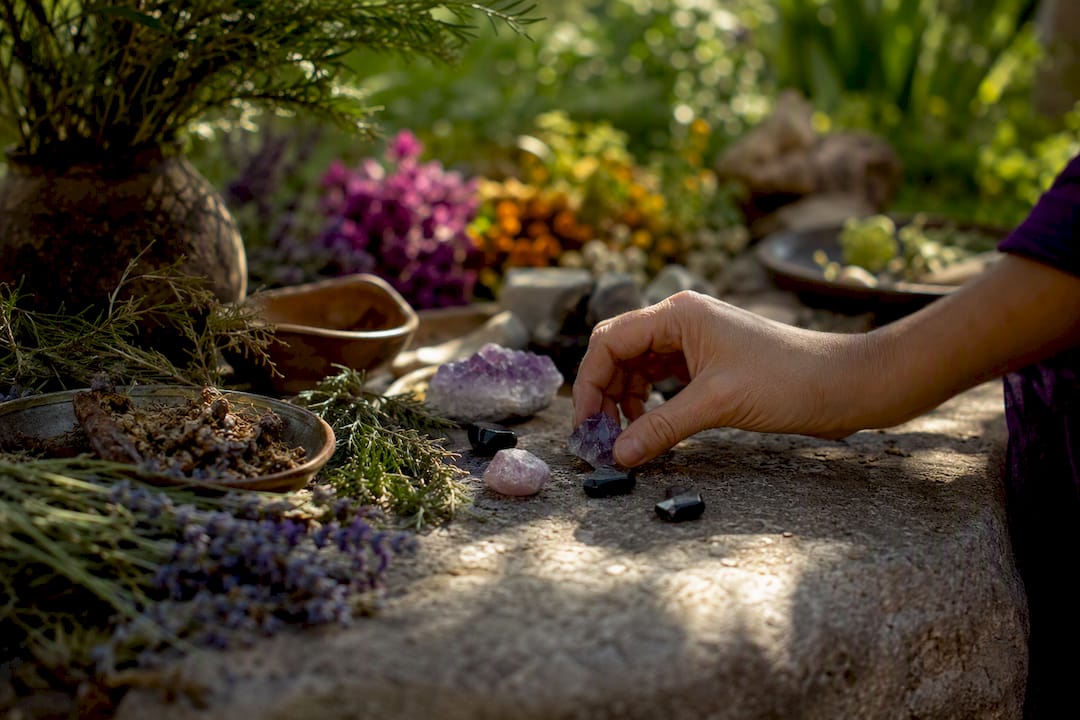 Hand placing grounding stones on altar